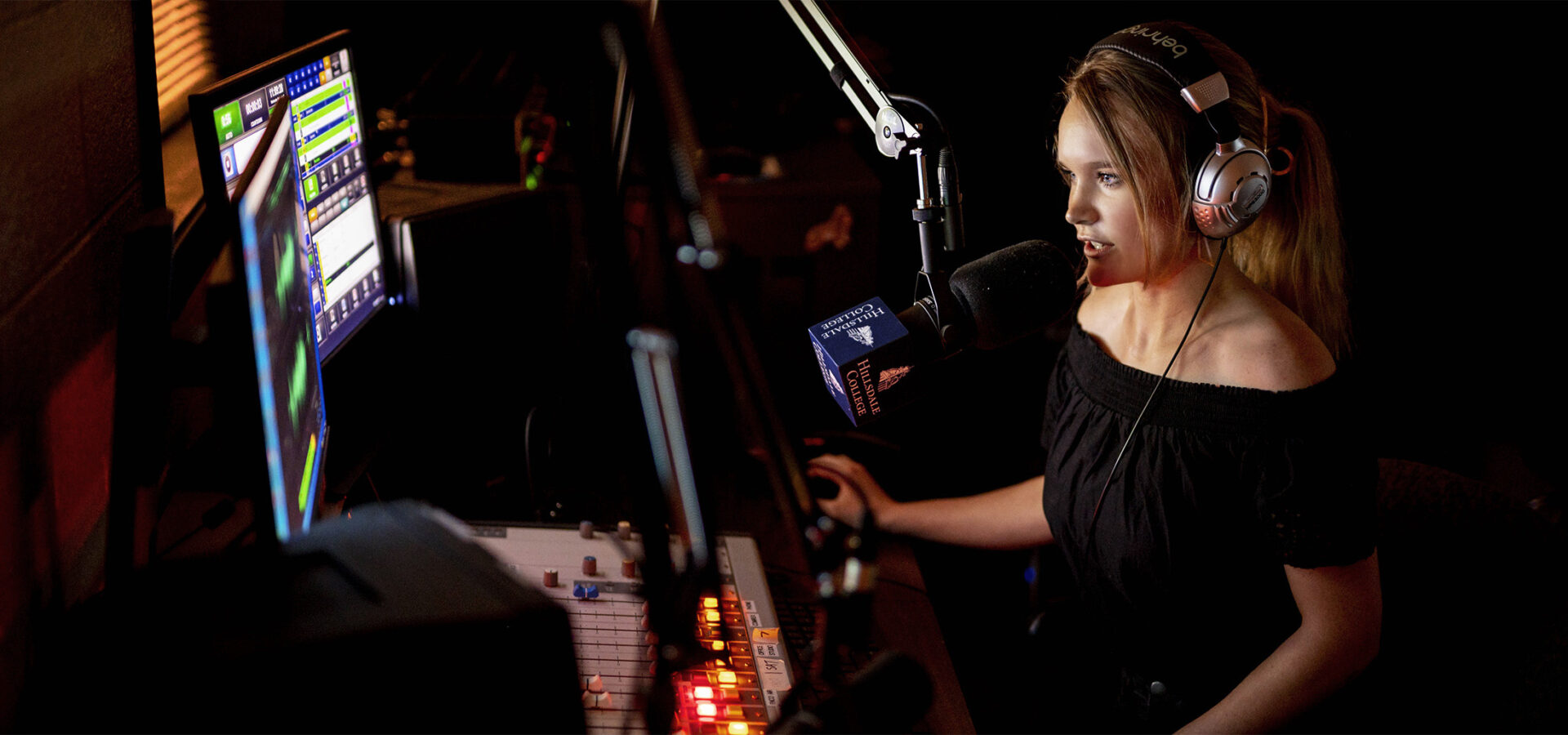A Hillsdale journalist student speaking into a microphone in the Hillsdale broadcast studio
